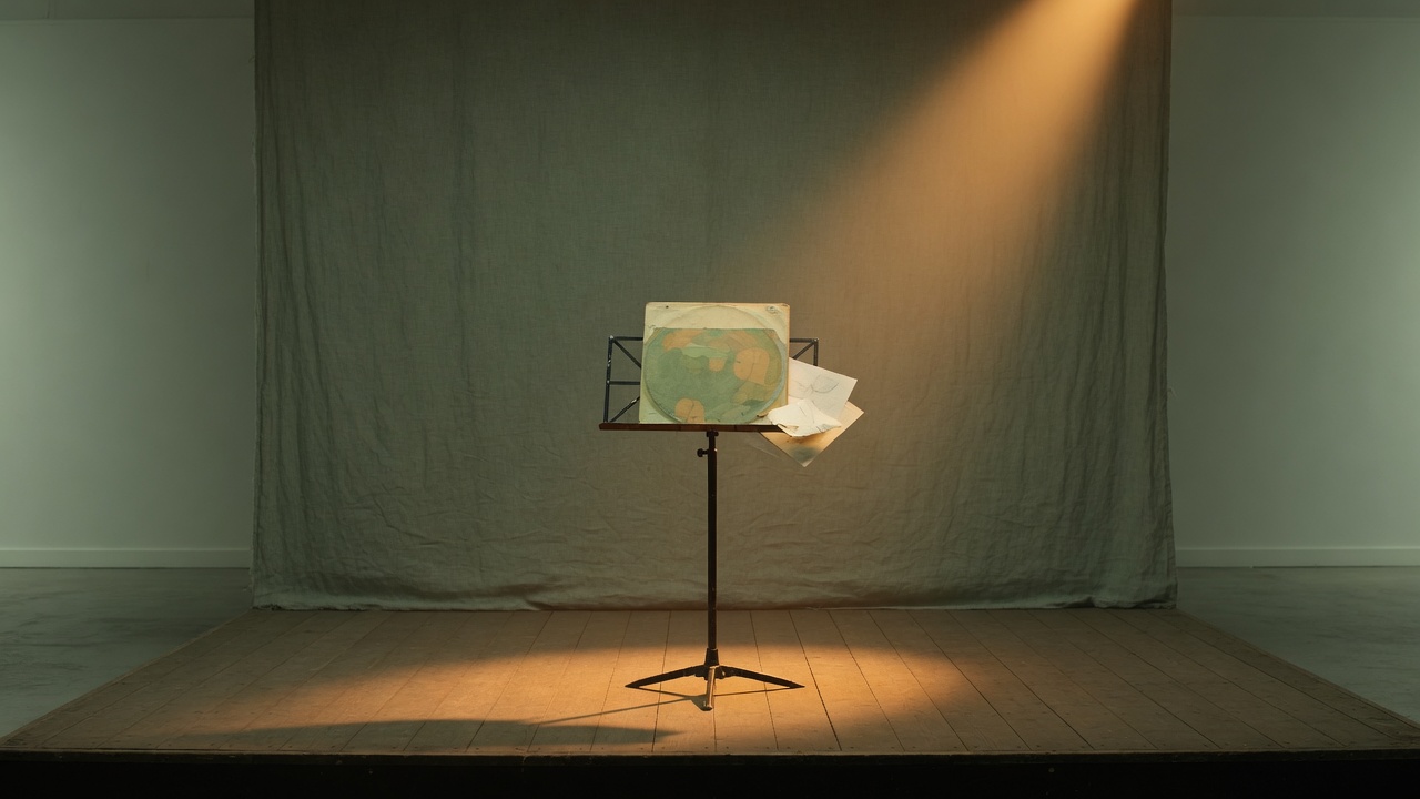Empty stage with a vinyl sleeve on a music stand under a warm spotlight